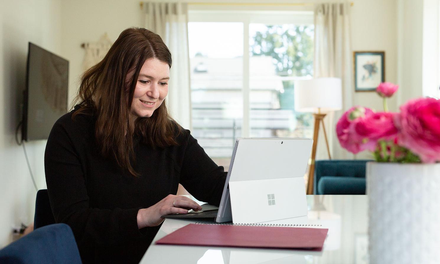 An MBA student works on her laptop at home | photo by Chris Baron